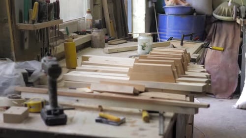 A Carpenter in the Workshop Lubricates Furniture Parts with Glue in the Workshop