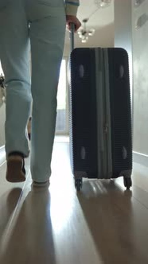 Mulher rola a mala pelo corredor no momento da partida do apartamento