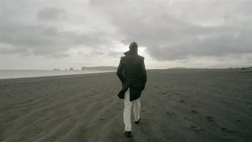 A Young Man Taking a Leisurely Stroll on Reynisfjara Black Sand Beach Located in South Iceland