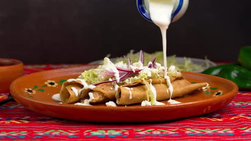 Tasty Tacos Being Drizzled with Cream Sauce