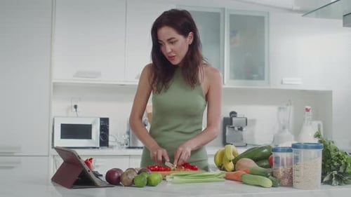 Woman Chopping Vegetables in Bright Kitchen