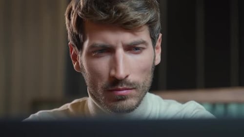 Portrait of a Young Designer Working on a Laptop Focused Man Looks at the Camera the Thinking