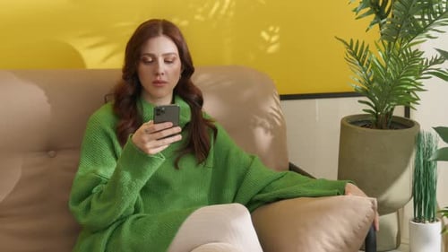 Woman Using Smartphone While Relaxing on Couch
