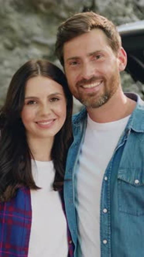 Smiling Couple Posing in Front of a Stone Wall