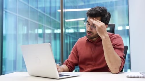 Stressed Young Adult Man Working at Laptop