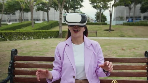 Young Woman Using VR Glasses on Bench in City Park