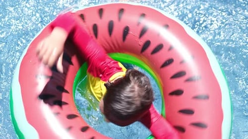 Little Boy Enjoys the Freshness in the Pool the Boy is Playing with Water in the Pool Spinning
