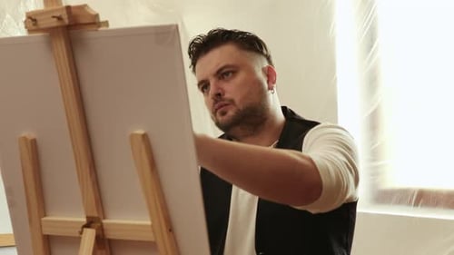 Man Painting on Canvas in Art Studio