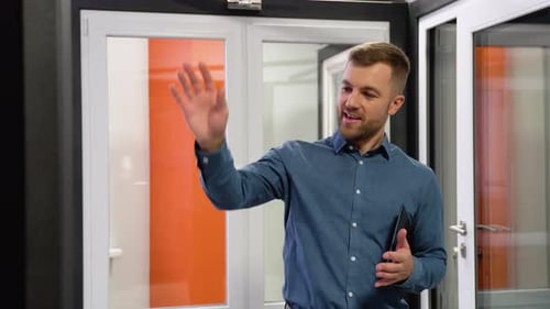 Friendly Manager in Window Shop Makes a Presentation of New Products