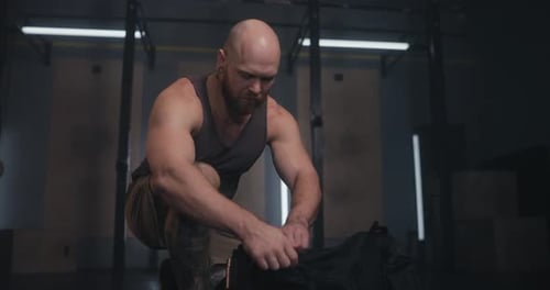Man Packing Gym Bag at Fitness Center