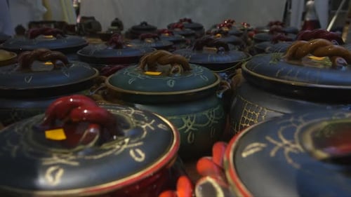 old fashioned style clay bowls with lids on counter at craft market