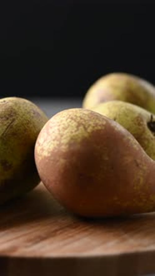 Fresh pears rotating on dark background with dramatic lighting