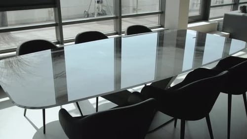 Conference Room in a Building with Glass Table Chairs and Window View