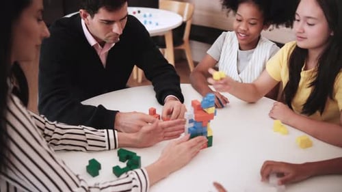 Adults and Children Play with Colorful Toy Blocks
