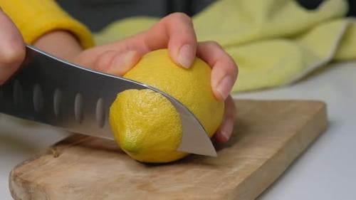Mujer cortando un limón en la tabla de cortar limón cortado a mano en la tabla de cortar, primer plano, jugoso limón
