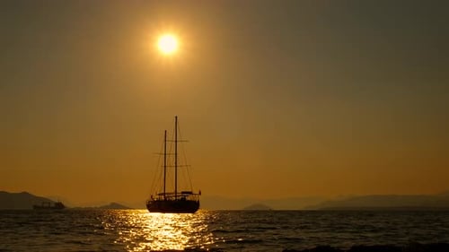 View of Waves with Ship Silhouette During Dusk