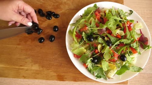 60. Vegetable salad is prepared, adding olives.