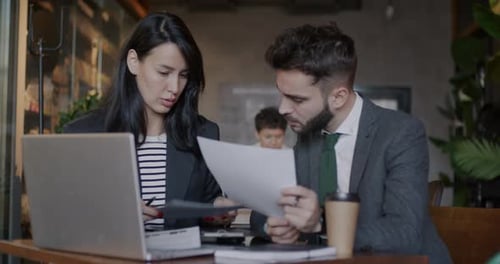 Business Partners Man and Woman Working with Documents Talking Discussing Project in Cafe