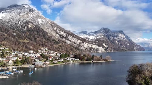 A Breathtaking View of a Quiet Lakeside Village Under Mountains