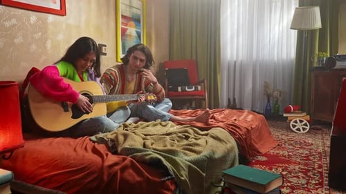 Young People Enjoying Music and Relaxing in Cozy Bedroom Setting
