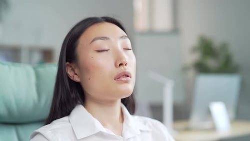 Young Adult Meditates in Office Chair, Relaxing