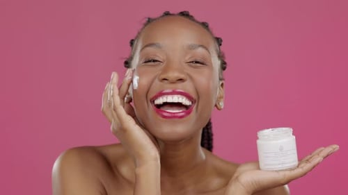 Woman Applying Face Cream, Pink Background