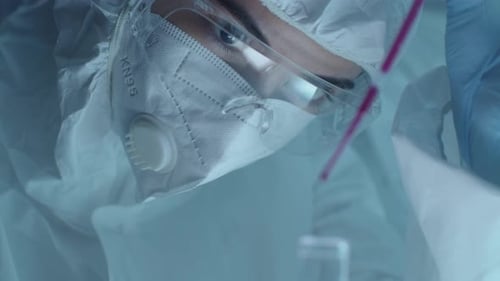 Scientist Drops Liquid into Flask in Laboratory