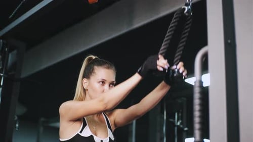 Porträt einer schönen jungen athletischen Frau, die im Fitnessstudio mit rotem Neonlicht trainiert