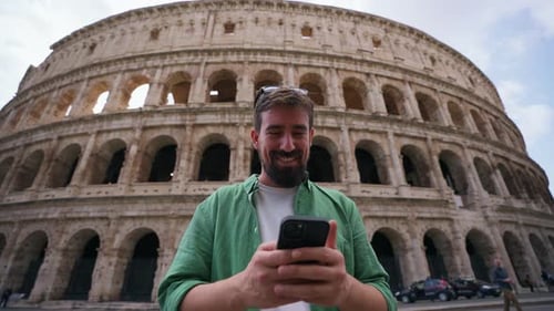 Man uses Phone at Colosseum on Sunny Day
