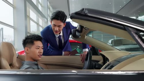 Car Salesman Talking to Customer in Showroom