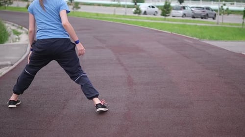 Woman is Warming Up in Building Urban Park Young Girl Preparing to Jogging in Sport Wear on the