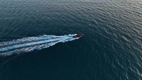 An Expensive Boat with Men on Board Sails Into the Sea at Sunset Cinematic Shooting From a Drone the