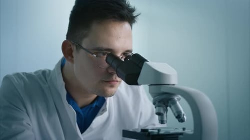 Scientist Looks Through Microscope in Modern Lab