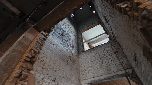 White brick walls of the old shabby elevator shaft. Low angle view at the lift pit in the building