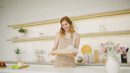 Woman Baking and Smiling in Modern Kitchen