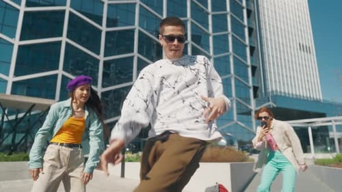 Young And Stylish Male Hip Hop Dancer Is Freestyling On City Street In the Circle Of Friends. Grou