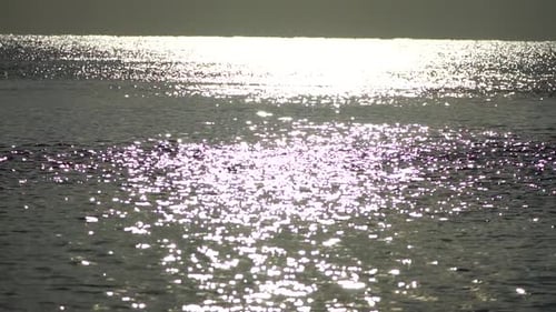 Abstrakte strahlende Sonnenreflexionen auf der blauen Oberfläche von Meereswellen