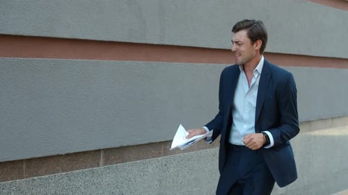 Excited Business Man Celebrating Victory Near Office Building. Joyful Businessman Throwing Papers