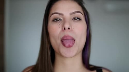 Jeune femme montrant sa langue. Jolie fille qui sort la langue avec une expression amusante