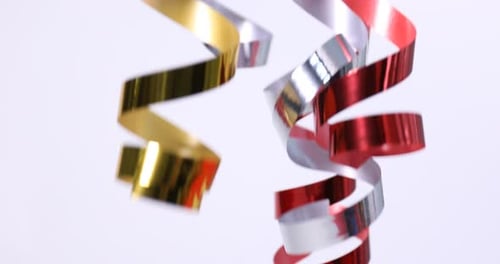 Gold, Silver and Red Metallic Curling Ribbons Against White