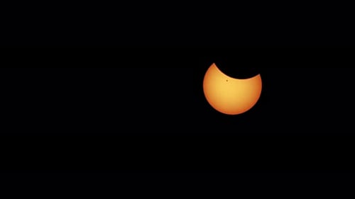 Verkleinern der partiellen Sonnenfinsternis mit sichtbarem Sonnenfleck auf dem Gesicht der Sonne und Verdunkelung der Gliedmaßen