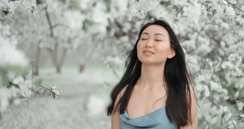Young Woman Enjoying Spring Blossom in an Apple Orchard
