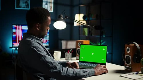 Schwarzer Mann erstellt einen Bericht mit Daten neben einem isolierten Chroma-Key-Display