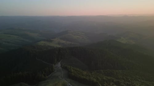 Flying Over Green Forest at Cloudy Day with the Mountains on Horizon with Glowing Clouds Carpathian
