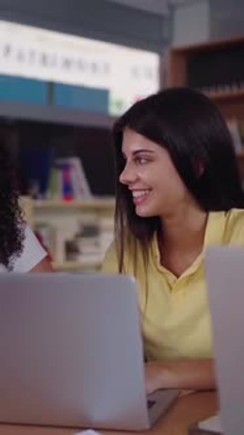 Group of Students at Library Gathering Together to Do a School Project As Teamwork Using a Laptop