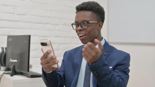 Young Man in Suit Celebrates Good News on Phone
