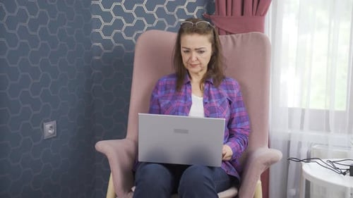 Woman Using Laptop in Chair Indoors