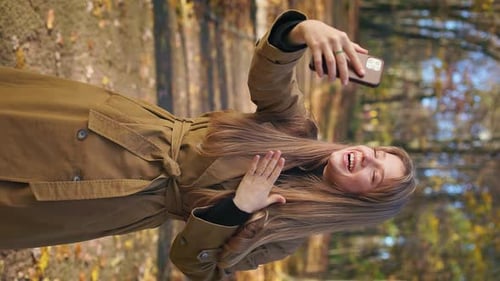 Pretty Young Female Walking in Park in Autumn Standing