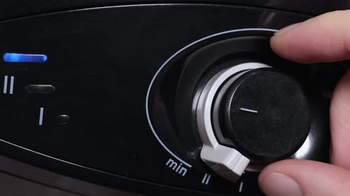 Finger Adjusting a Black Dial
