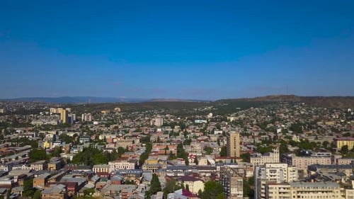 A smooth slow drone flight in a clear view under the blue sky, Tbilisi of the capital and the larges